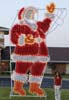 Daytime photo of large waving santa silhouette light display